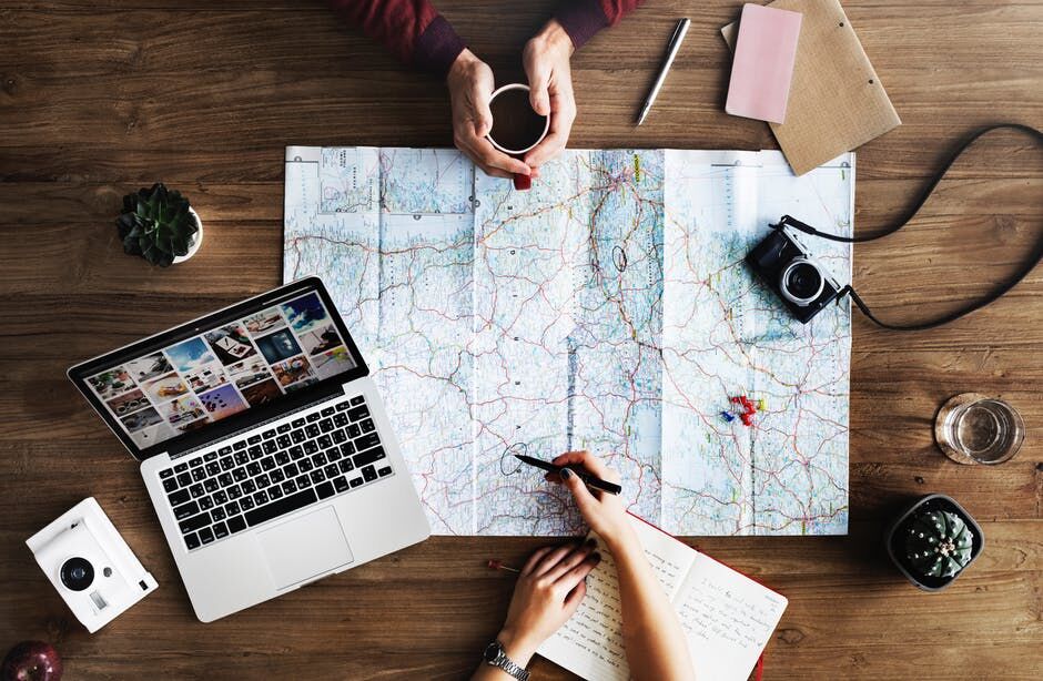 Two people are sitting at a table with a map and laptop.