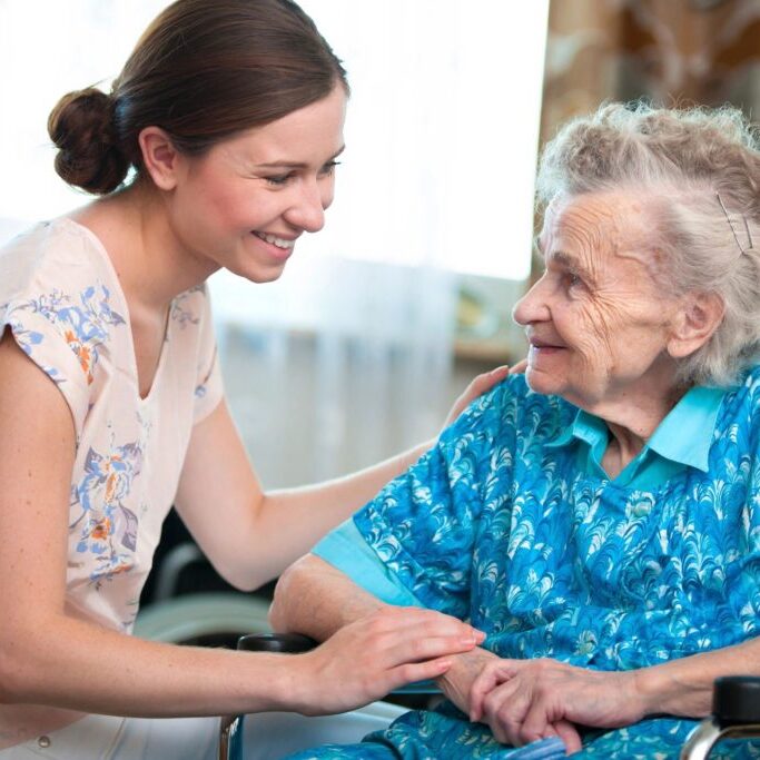 A woman and an old lady smiling for the camera.